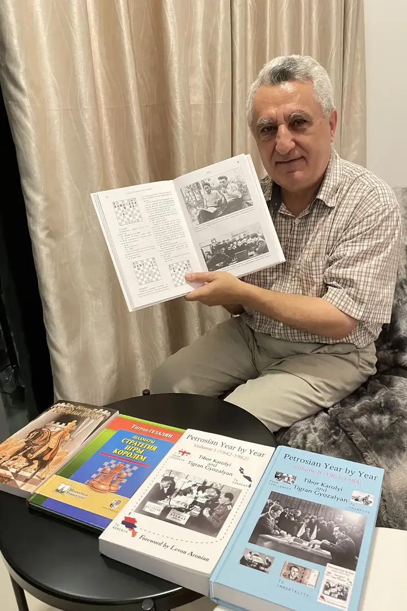 Coach Tigran Gyozalyan holding copies of his chess books